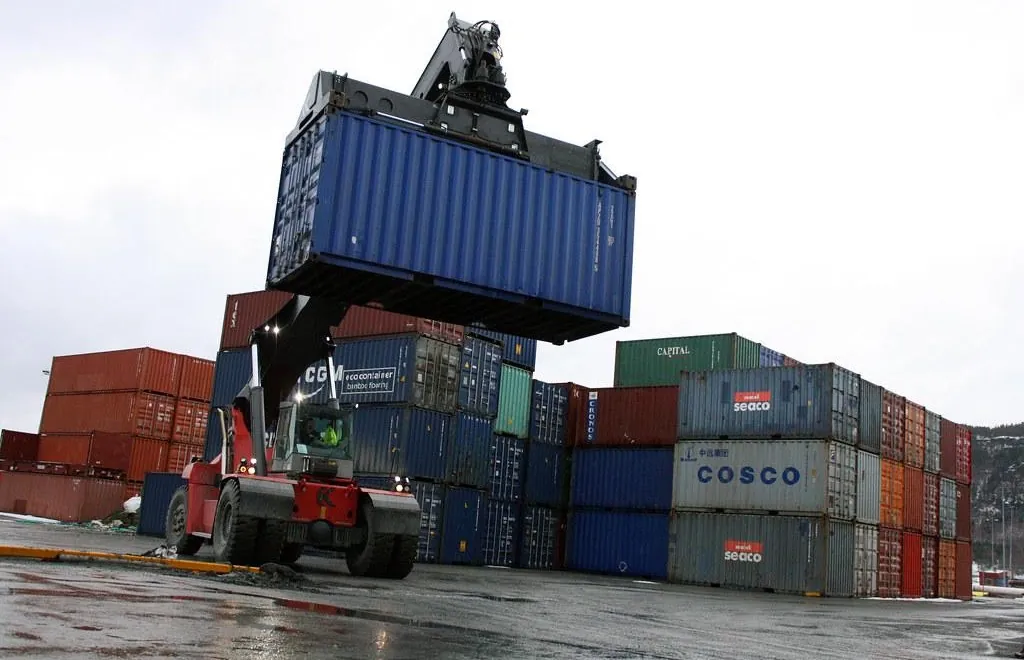 Reach stacker lifting a container in a container yard